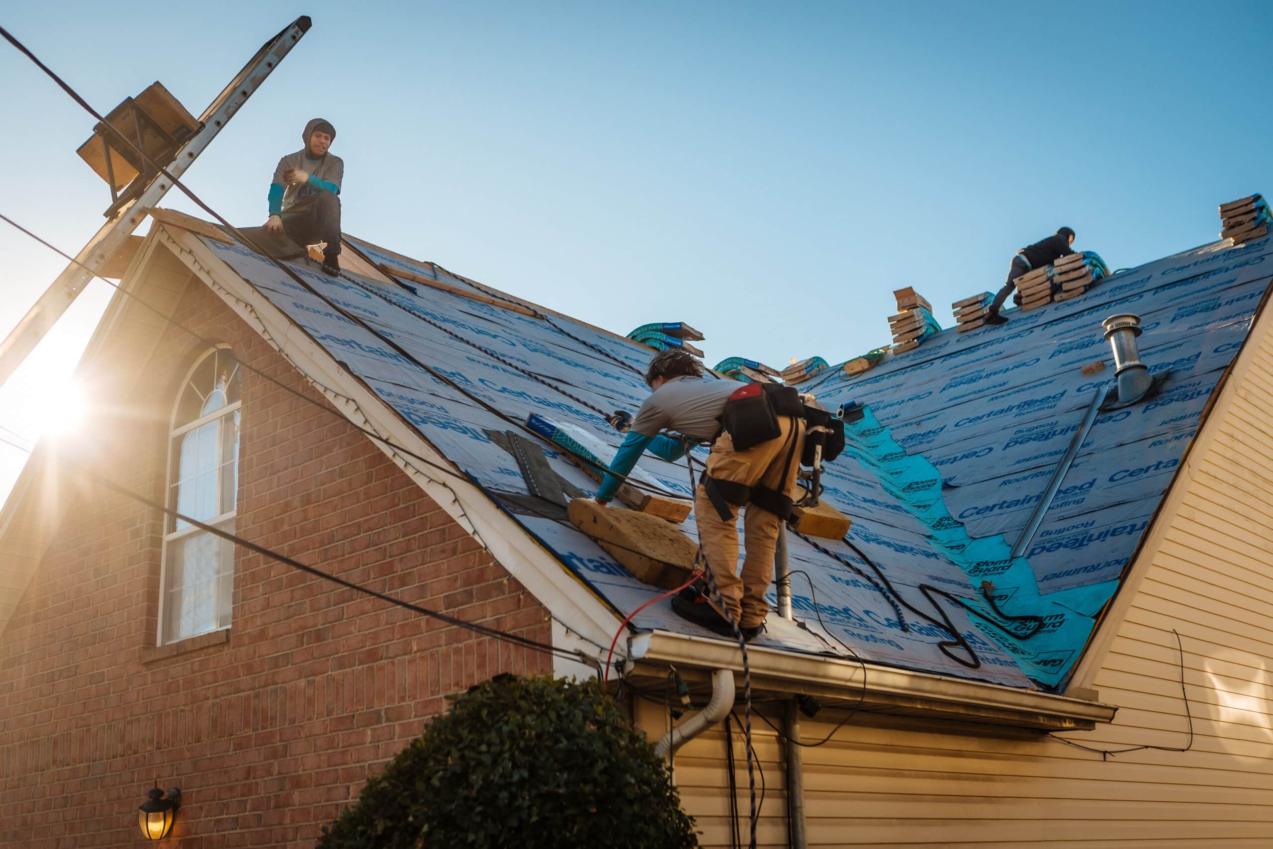 Roof Replacement in Nashville, TN 1 Nashville Roofing Company crew installing underlayment during a full roof replacement in Middle Tennessee, with shingle bundles staged on the ridge