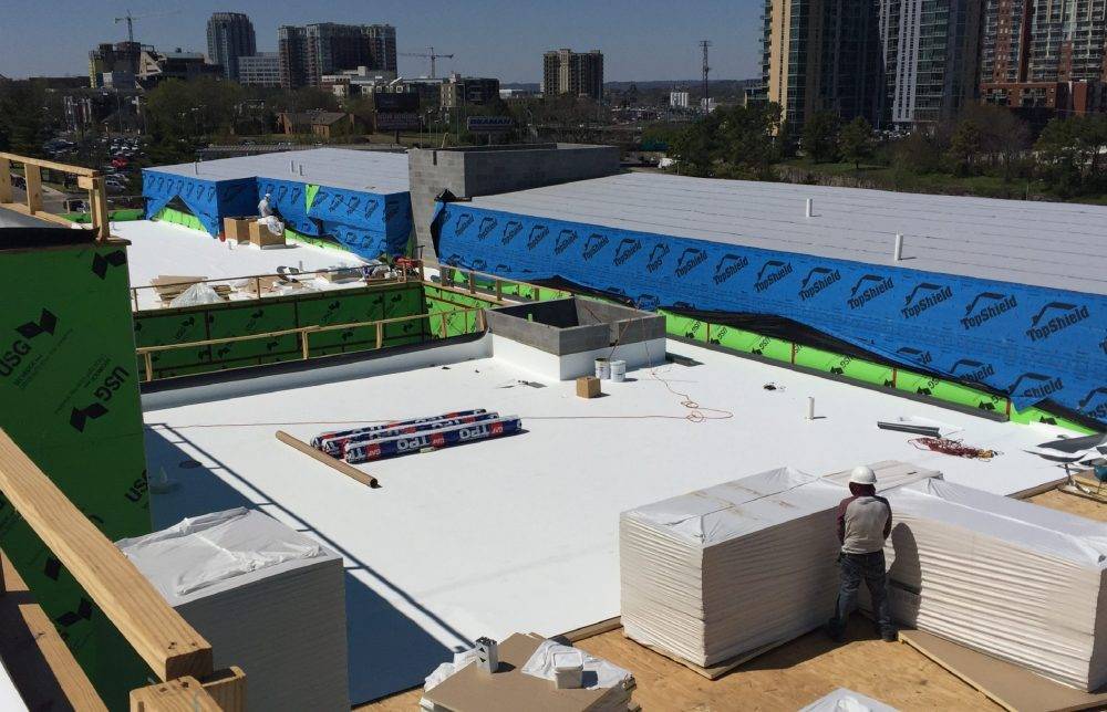 Commercial Roofing in Nashville, TN 1 TPO membrane rolls and insulation staged during a commercial low-slope roof installation in Nashville